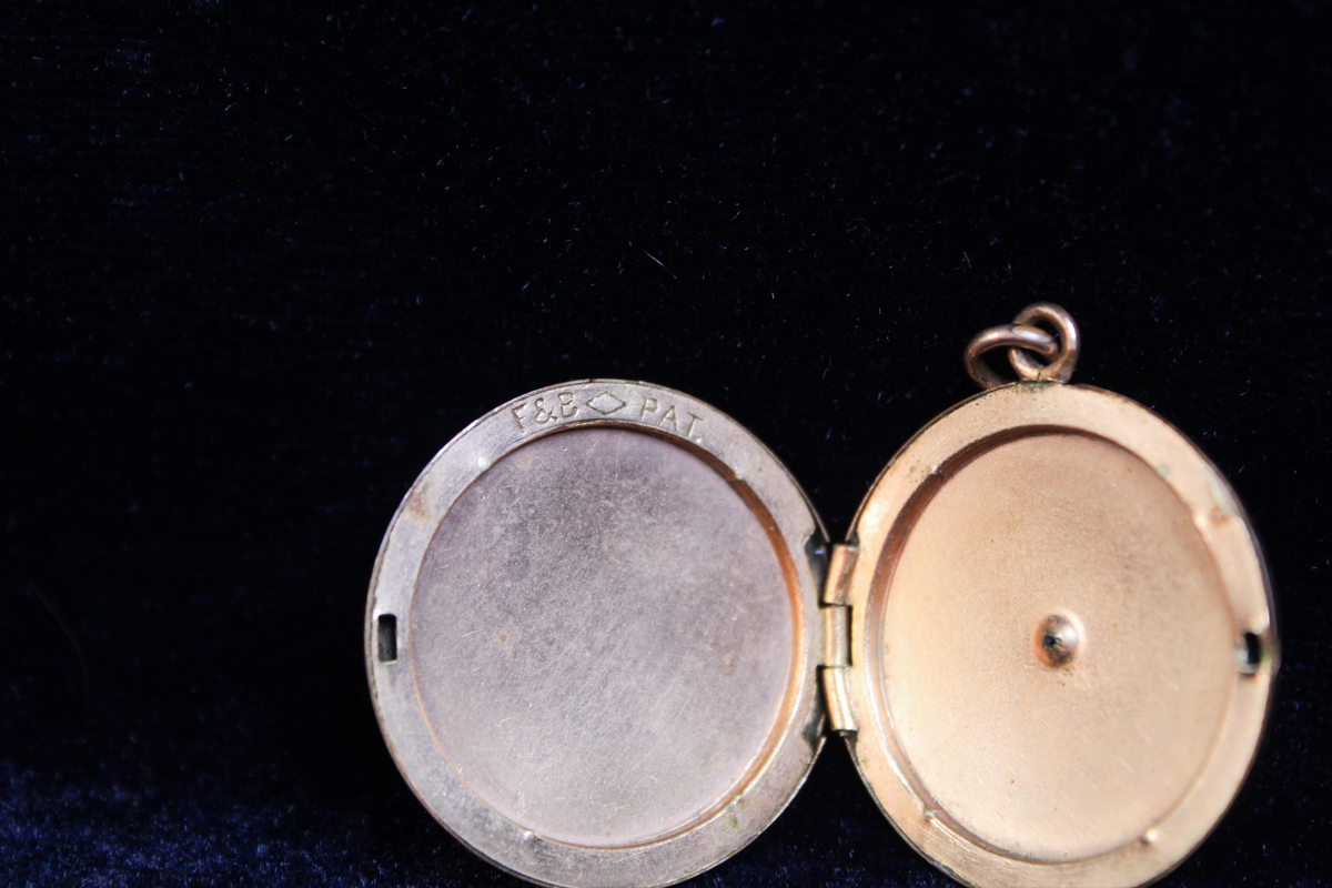 Antique gold plated Foster & Bailey locket, open, showing interior compartments and F&B PAT engraving.
