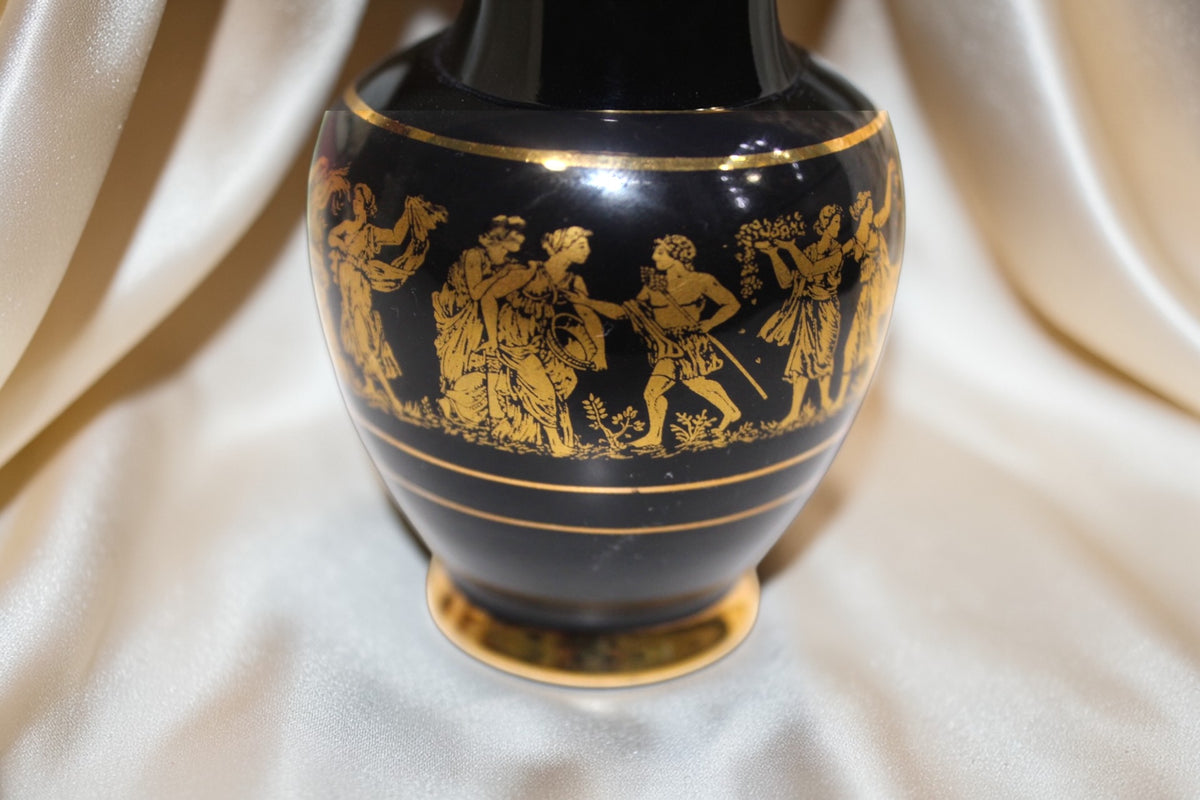 Black miniature vase with gold Grecian figures in procession, gold rim and base.