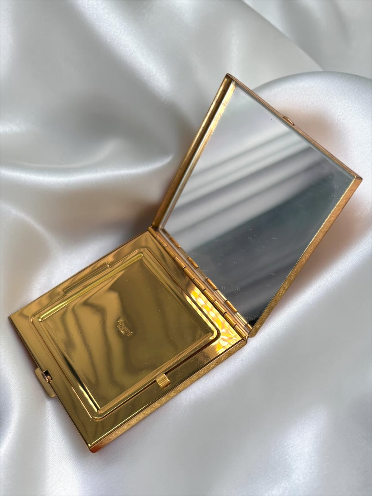 1950s Volupté gold-tone powder compact, open, showing mirror and powder compartment.