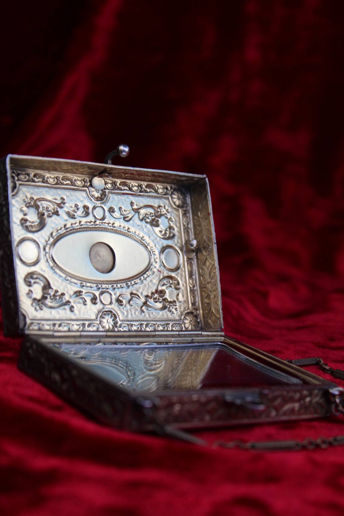 Antique French vanity case with ornate silver and brass detailing, open to reveal a mirrored interior.