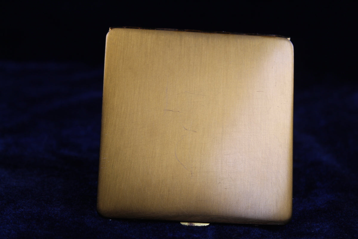 1940s gold tone vanity compact with a brushed finish and rounded edges.