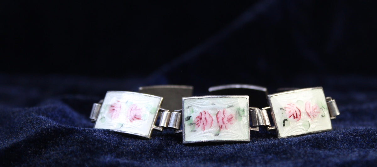 Sterling silver bracelet with rectangular enamel panels featuring hand-painted pink roses on a white guilloché background.