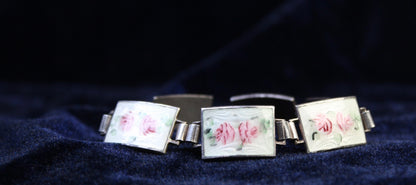 Sterling silver bracelet with rectangular enamel panels featuring hand-painted pink roses on a white guilloché background.