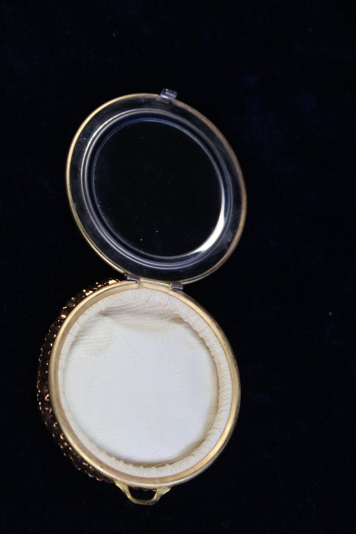 Gold tone mesh compact with guilloché enamel rose motif, open to show mirror and empty powder compartment.