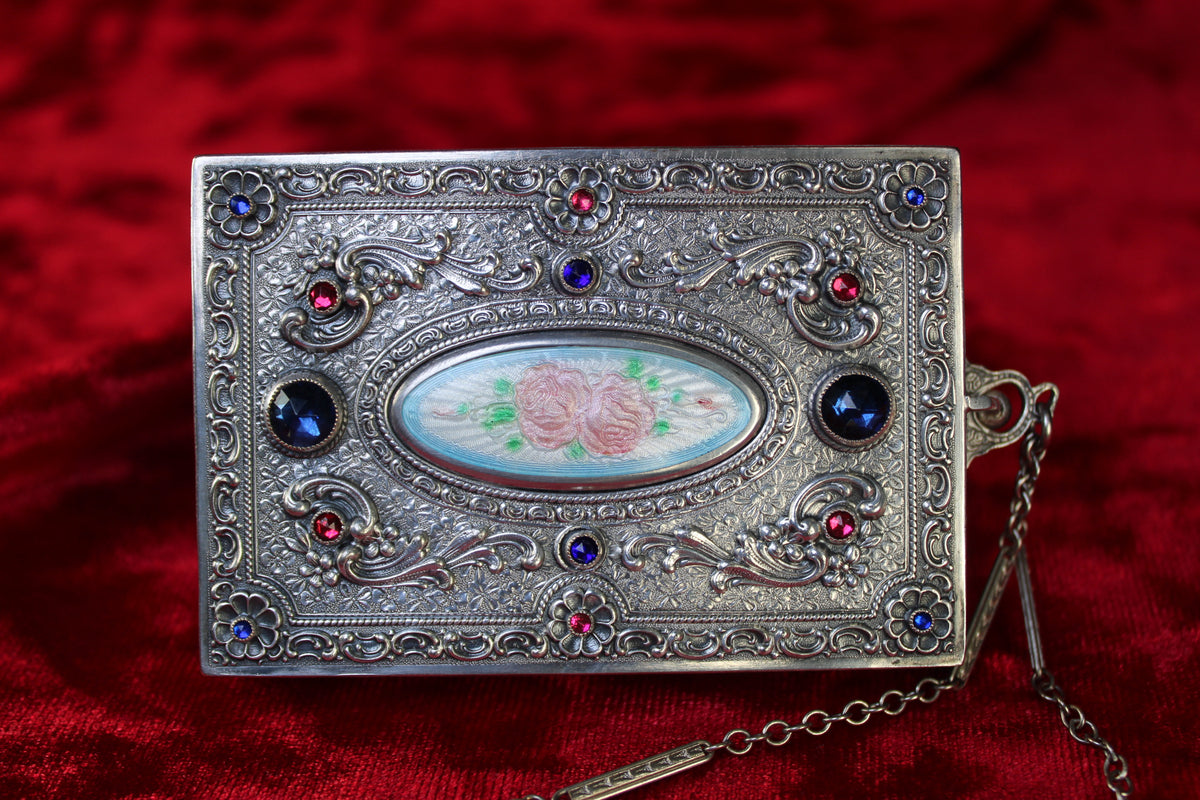 Antique French sterling silver compact with guilloché enamel rose, ruby, and sapphire stones, and attached chain.