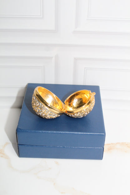 Jaestial Gilded Lace Round Trinket Box in vintage gold filigree, open on a blue box.
