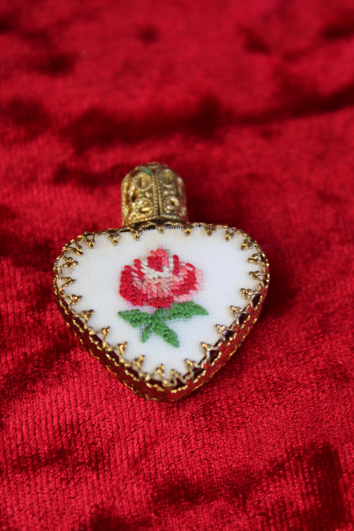 Austrian heart-shaped perfume bottle with gold filigree and petit point rose embroidery.