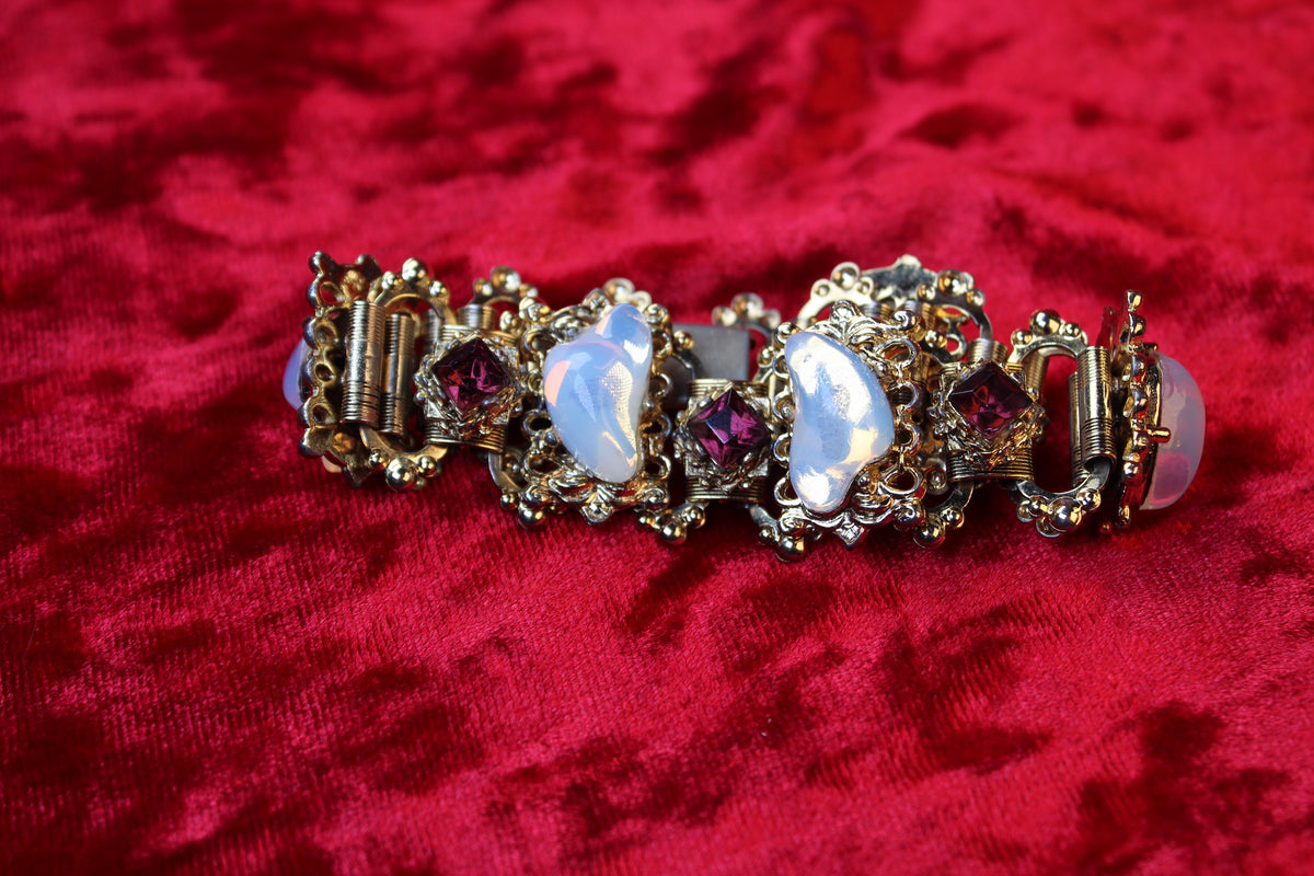 Gold tone bracelet with opalescent glass and garnet rhinestones in Victorian Revival style.