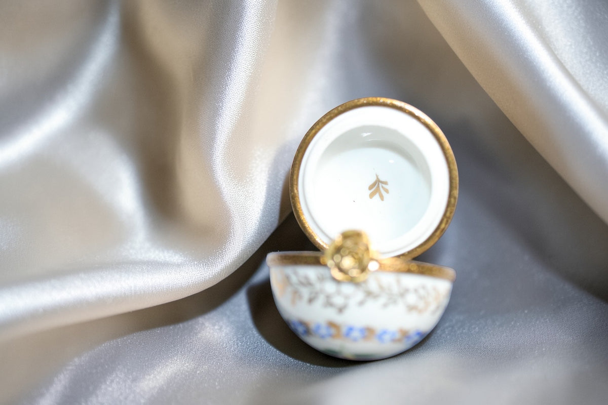 Jaestial hand-painted Limoges porcelain trinket egg with gold trim and floral design.
