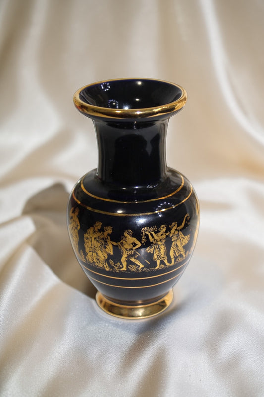 Black and gold miniature vase with a Grecian procession motif, featuring classical figures in gold against a dark background.