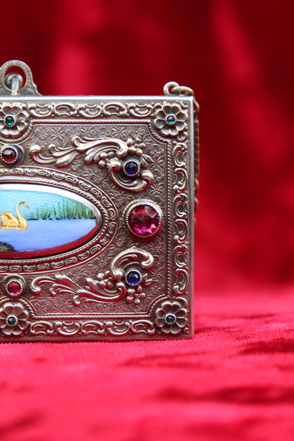 Antique French vanity case with hand-painted swan scene, repoussé metalwork, and jewel-toned stones.