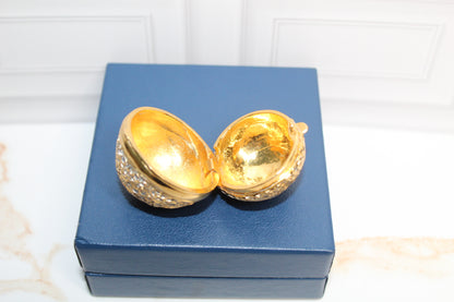 Jaestial Gilded Lace Round Trinket Box, open to reveal gold interior, on a blue box.