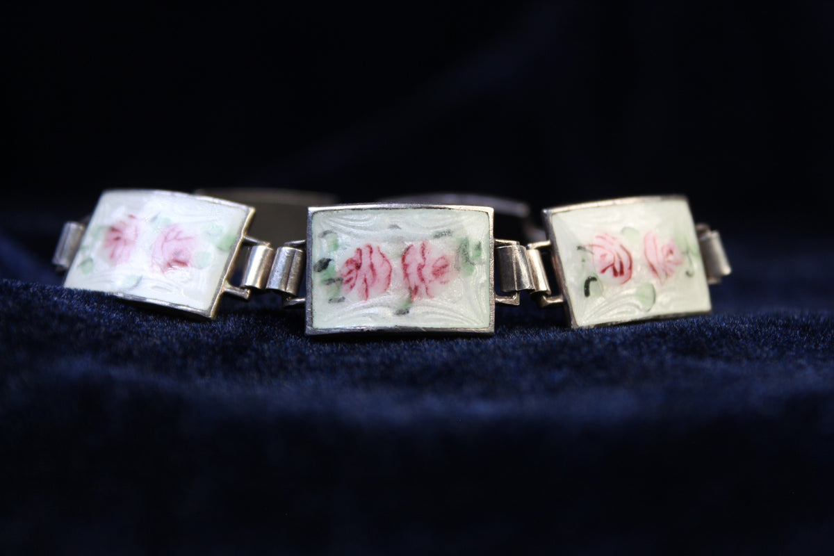 Sterling silver bracelet with rectangular panels featuring pink roses on white guilloché enamel.