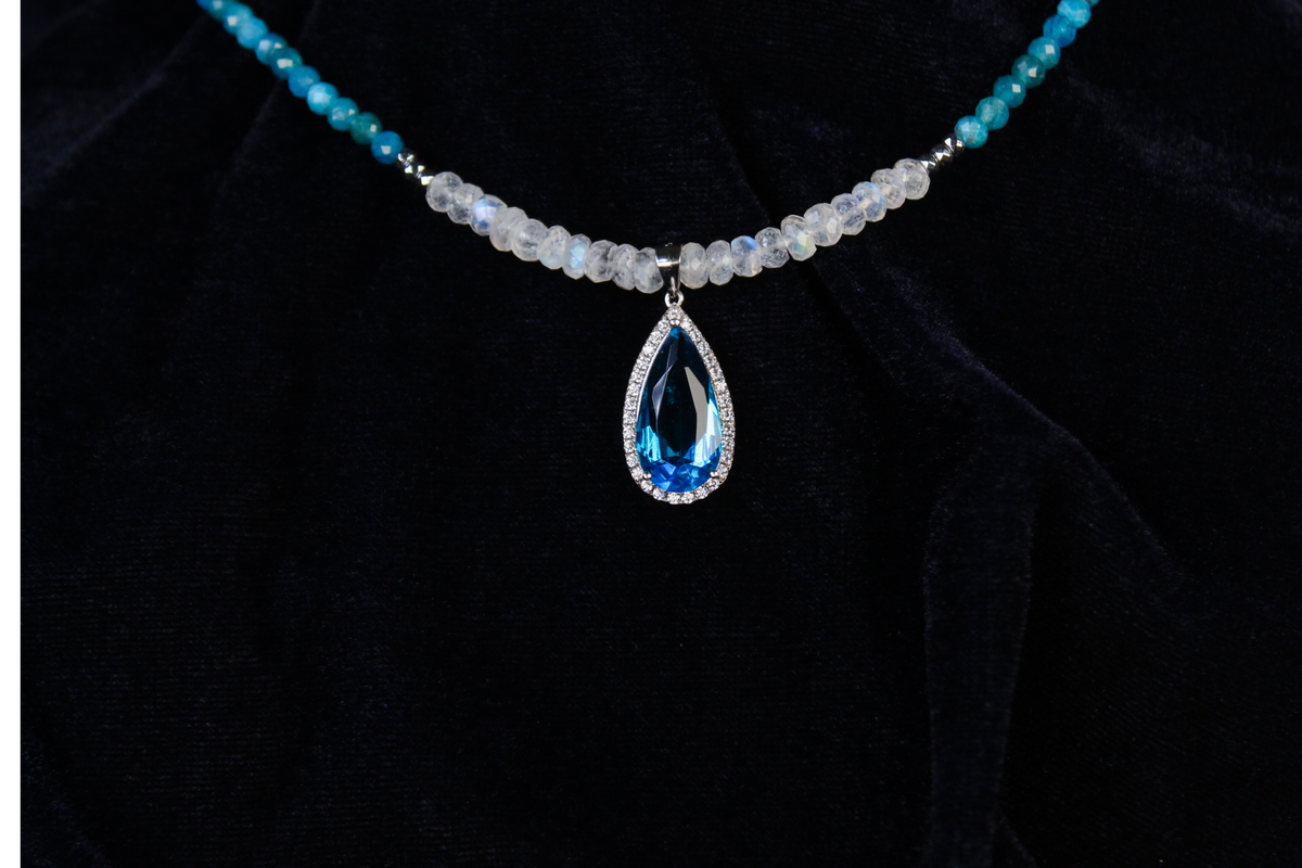 Sterling silver necklace with blue apatite, rainbow moonstone beads, and a teardrop blue gemstone pendant.