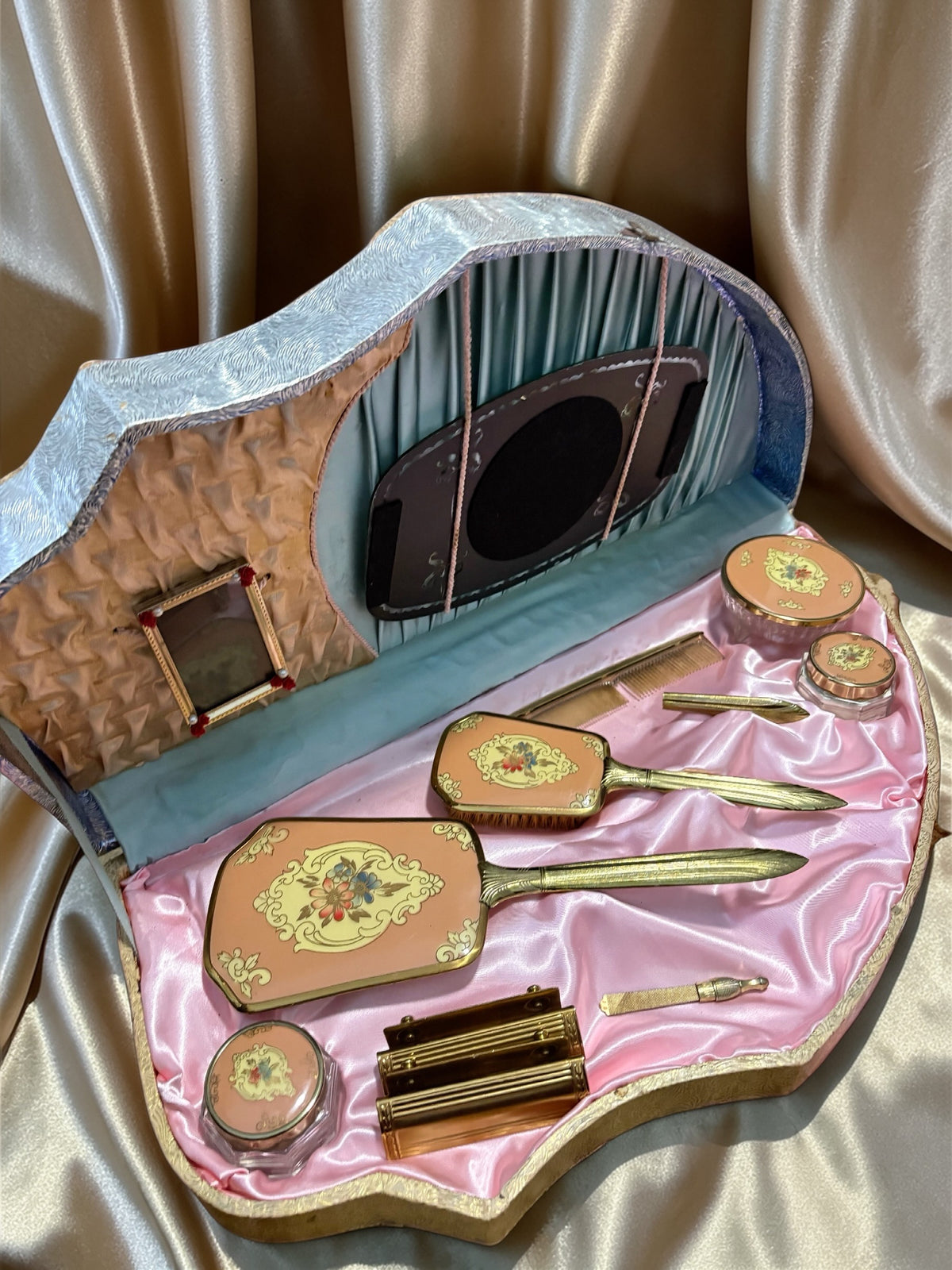 1940s vanity set with hand-painted florals in a shell-shaped case with pink satin lining.