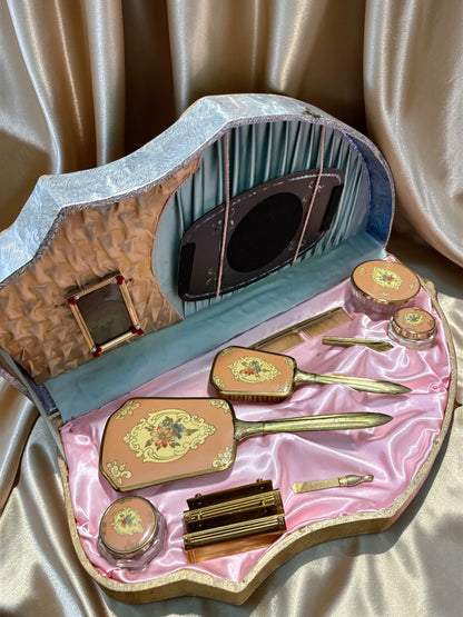 1940s vanity set with hand-painted florals in a shell-shaped case with pink satin lining.