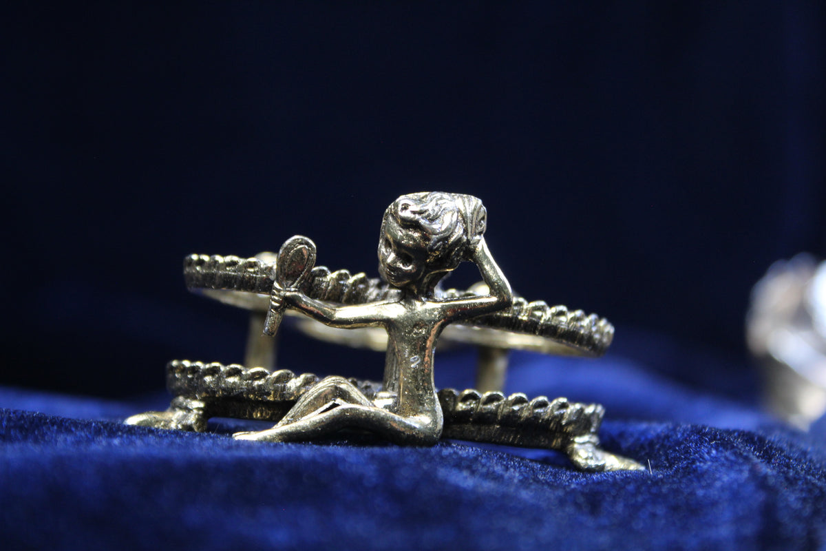 Gold-tone vintage lipstick holder with a figural girl holding a mirror and rose details.