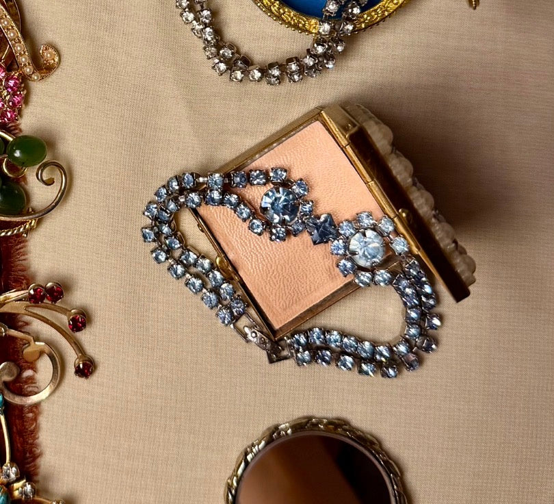 Jaestial Blue Radiance Tennis Bracelet with blue rhinestones on a pink compact.