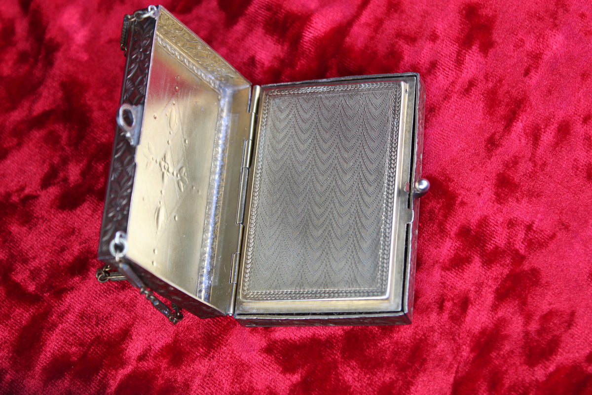 Antique French vanity case with guilloché detailing and ornate metalwork, open to reveal interior.