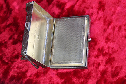 Antique French vanity case with guilloché detailing and ornate metalwork, open to reveal interior.