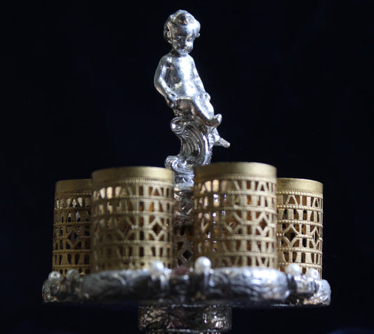 Art Deco cherub lipstick holder with ornate base and gold filigree cups.