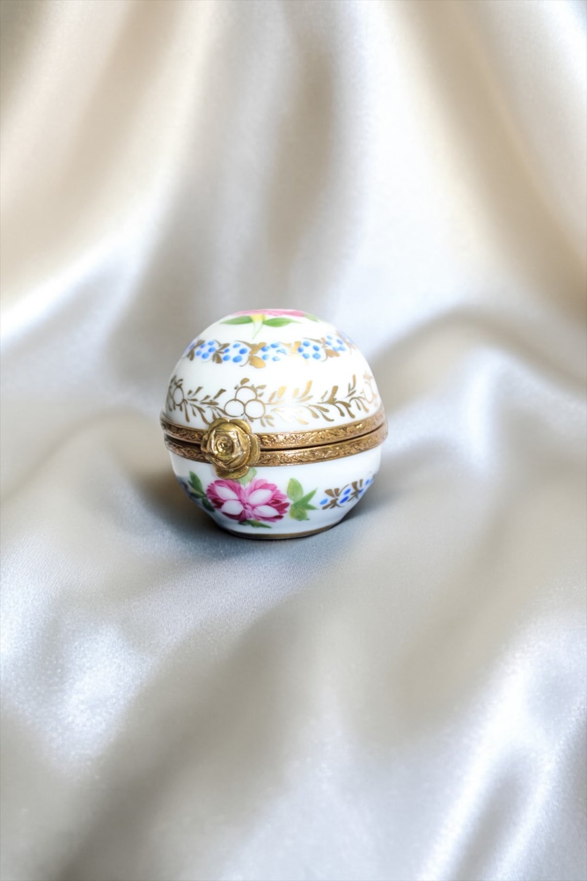 Jaestial hand-painted Limoges porcelain trinket egg with floral design and gold clasp.