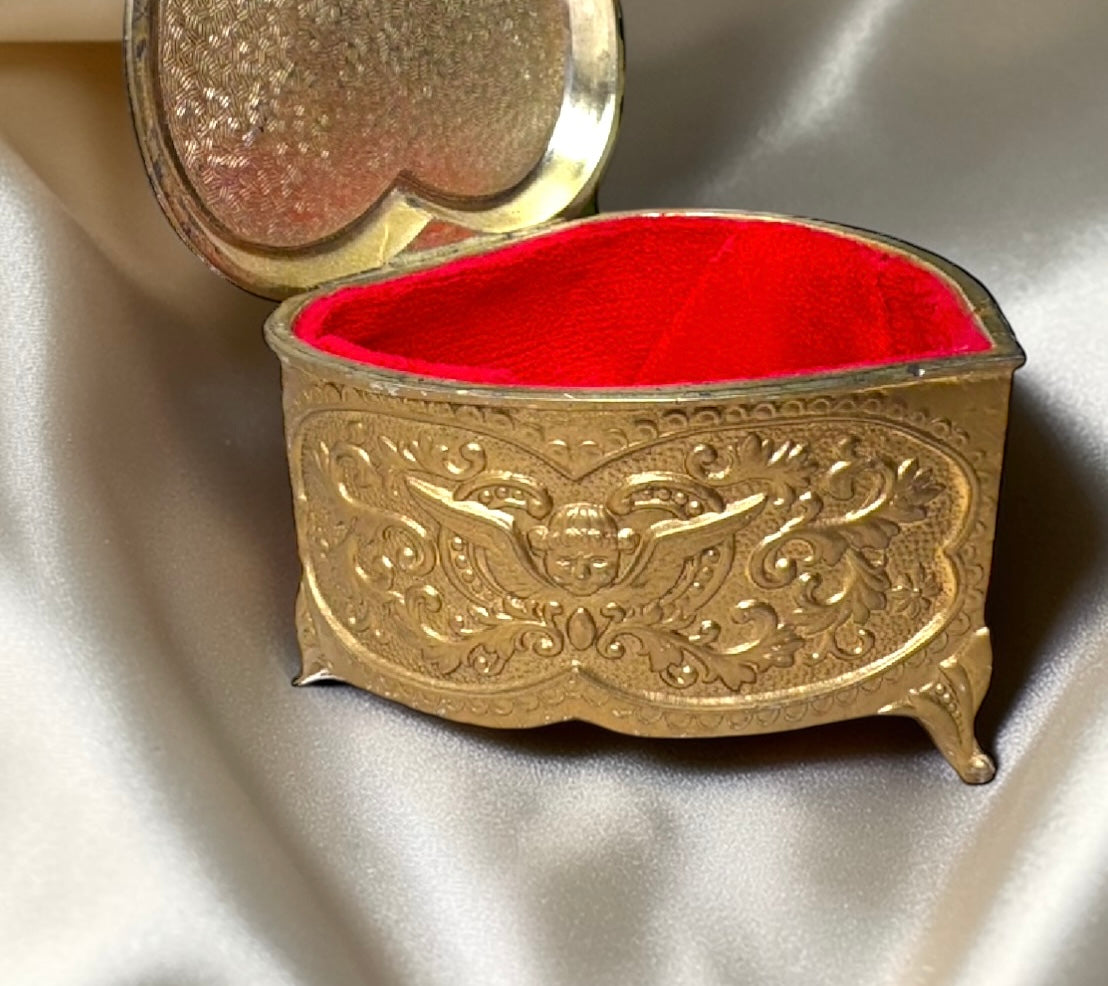 Vintage heart-shaped brass jewelry box with ornate Victorian design and red velvet interior.