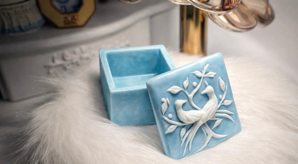Blue Incolay stone trinket box with carved lovebirds and foliage on the lid.
