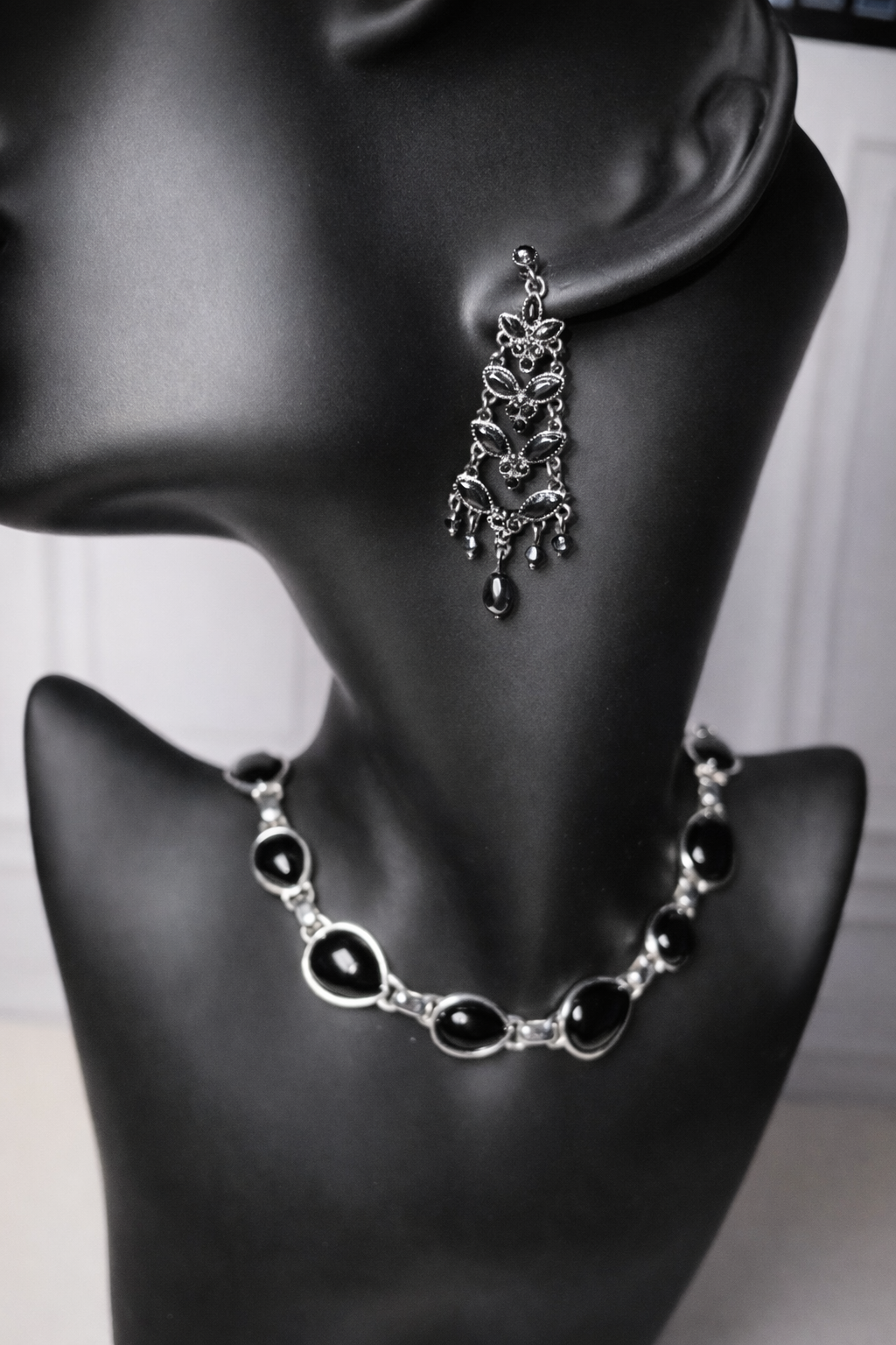 Vintage black crystal chandelier earrings and matching necklace on a black mannequin.
