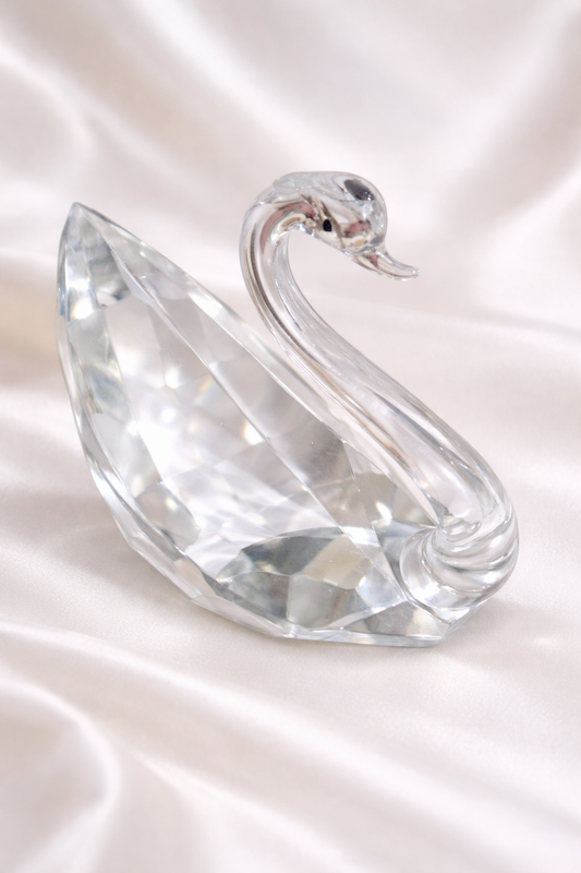 Clear faceted glass swan figurine with a curved neck and geometric body.