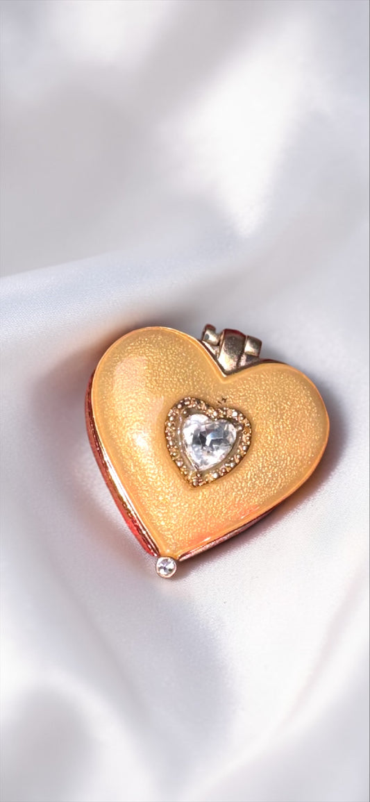 Gold-tone heart-shaped trinket box with a central rhinestone heart on the lid.