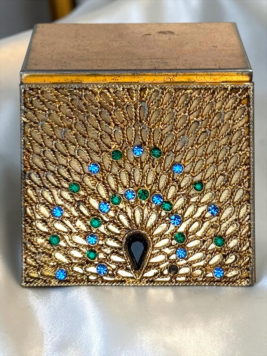 1940s gold-tone compact with ornate peacock filigree, blue and green rhinestones, and a black teardrop stone.