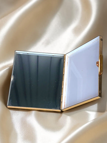 1940s ornate gold peacock filigree compact with rhinestones, open to show mirror and compartment.