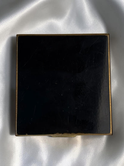 1940s black enamel compact with floral basket motif and gold trim.