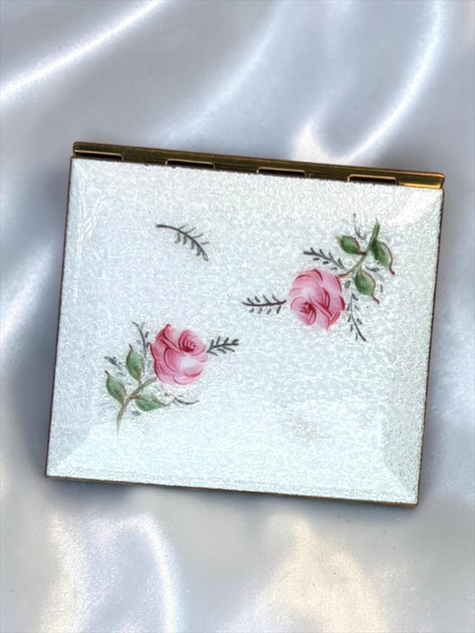 1940s compact with guilloché enamel, hand-painted roses, and a shimmering ivory background.