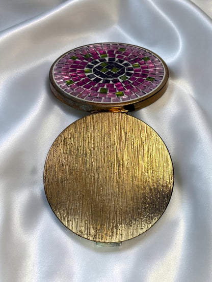 1940s vanity compact with pink and green mosaic glass lid and textured gold base.